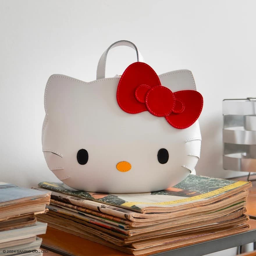 Hello Kitty collaboration bag displayed on stacked magazines